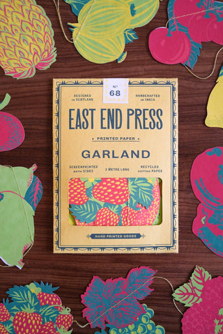 Verpackung der Früchte-Girlande von East End Press zwischen einzelnen Papierfrüchten