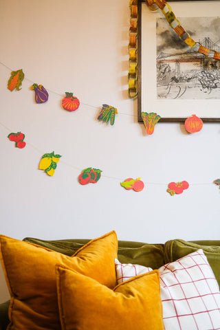 Früchte-Girlande von East End Press an einer Wand über einem Sofa