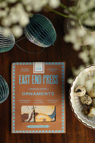 Verpackung der Papiervögel von East End Press auf einem Holztisch