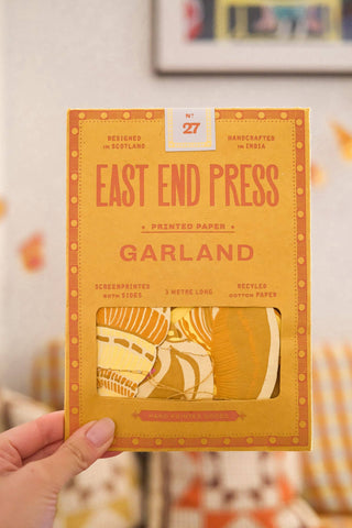 Verpackung der Muschel-Girlande von East End Press in der Hand