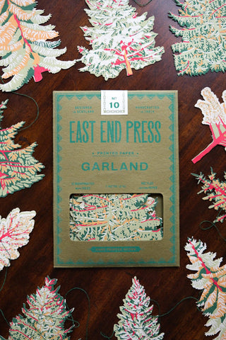 Verpackung der Wald-Girlande von East End Press zwischen Papiertannen