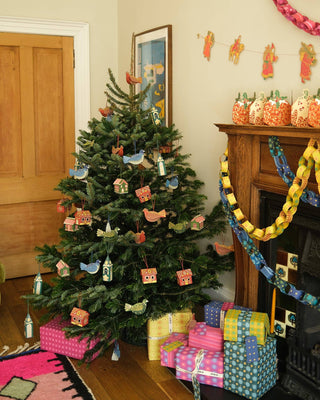 Weihnachtsbaum mit Papieranhängern und Girlanden von East End Press