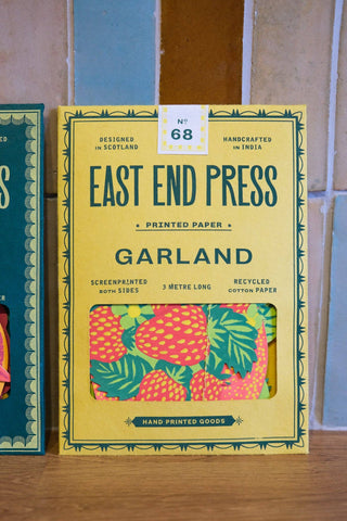 Verpackung der Früchte-Girlande von East End Press vor gefliester Wand