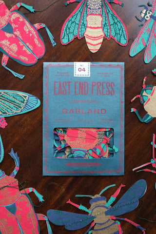 Verpackung der Insekten-Girlande von East End Press auf dunklem Holz