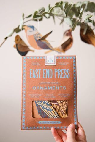 Verpackung und aufgehängte Papiervögel von East End Press